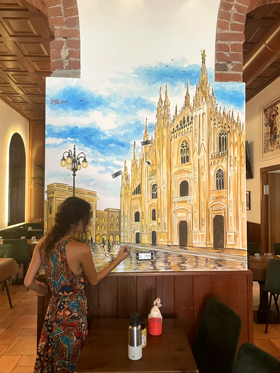 Giulia Dal Bon dipinge il Duomo di Milano sulla parete di un ristorante