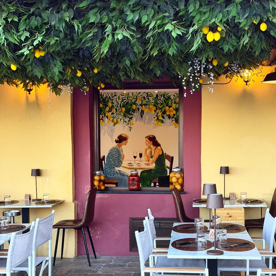 Murale di limoni dipinto da Giulia Dal Bon sotto un arco, in un ristorante