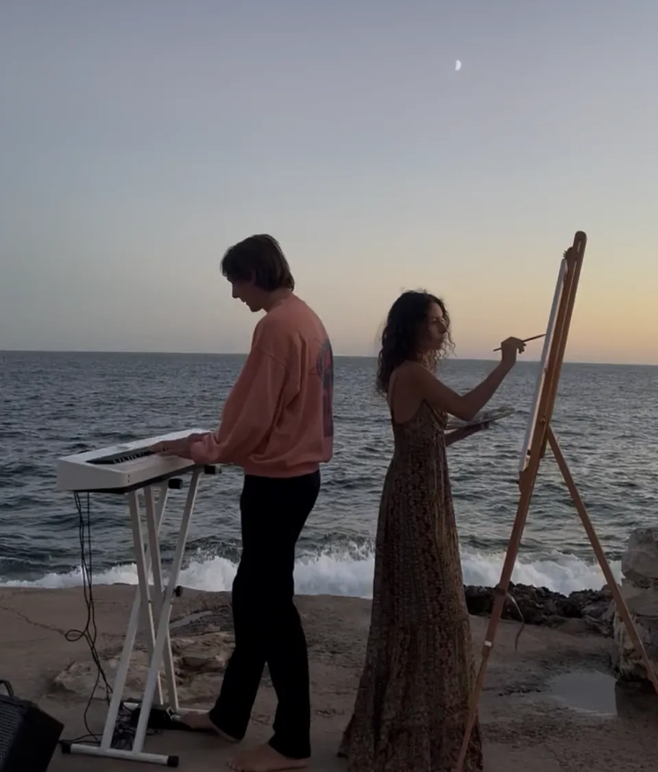 Orlando alla tastiera e Giulia Dal Bon al cavalletto, in riva al mare al tramonto