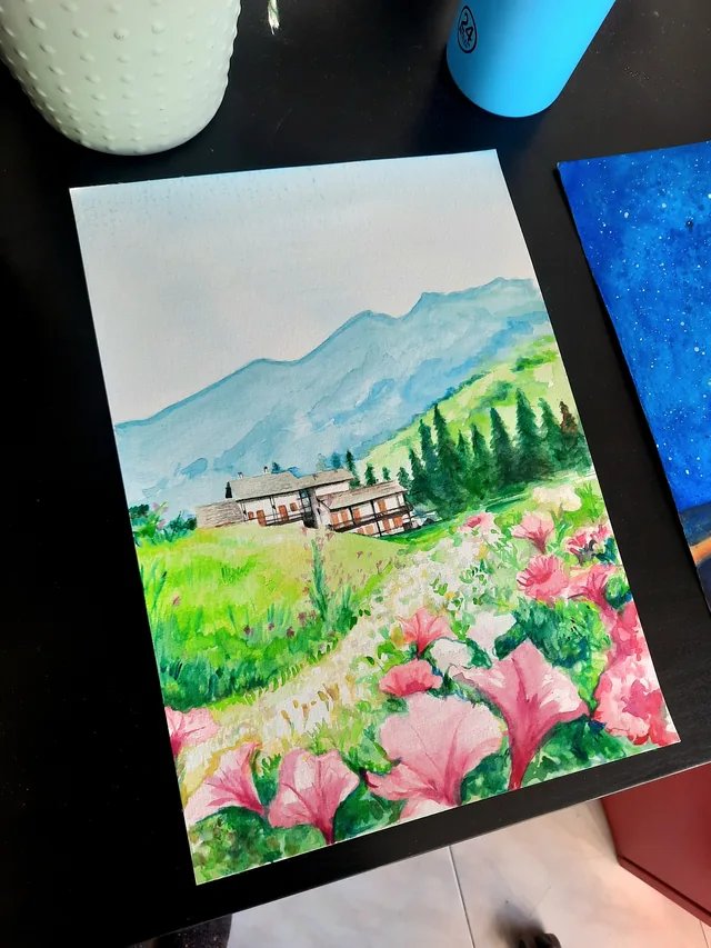 À l’aquarelle, Giulia Dal Bon a peint un chalet au pied des montagnes, au bout d’un chemin bordé de fleurs roses.