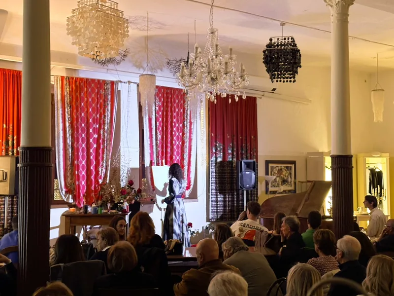 Live painting in a hall of crystal chandeliers: the audience watches Giulia Dal Bon paint on stage beside the grand piano.