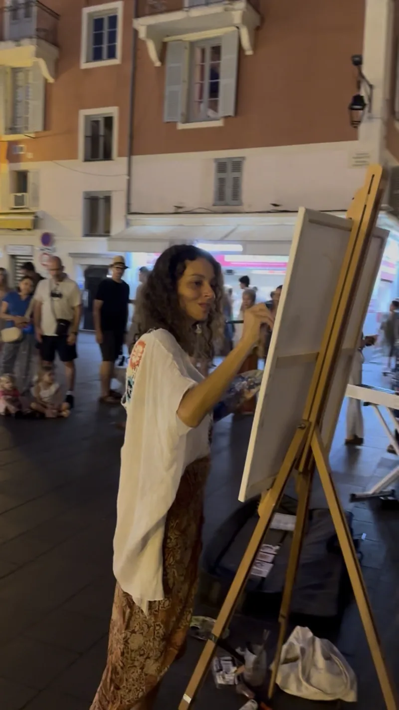 Live painting in a pedestrian street: one evening, Giulia Dal Bon paints among passers-by, who take the time to watch.