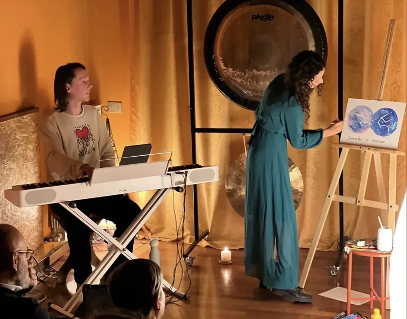 Devant le public, dans une salle aux tentures dorées, Giulia Dal Bon peint une toile bleue au son du clavier d’Orlando.