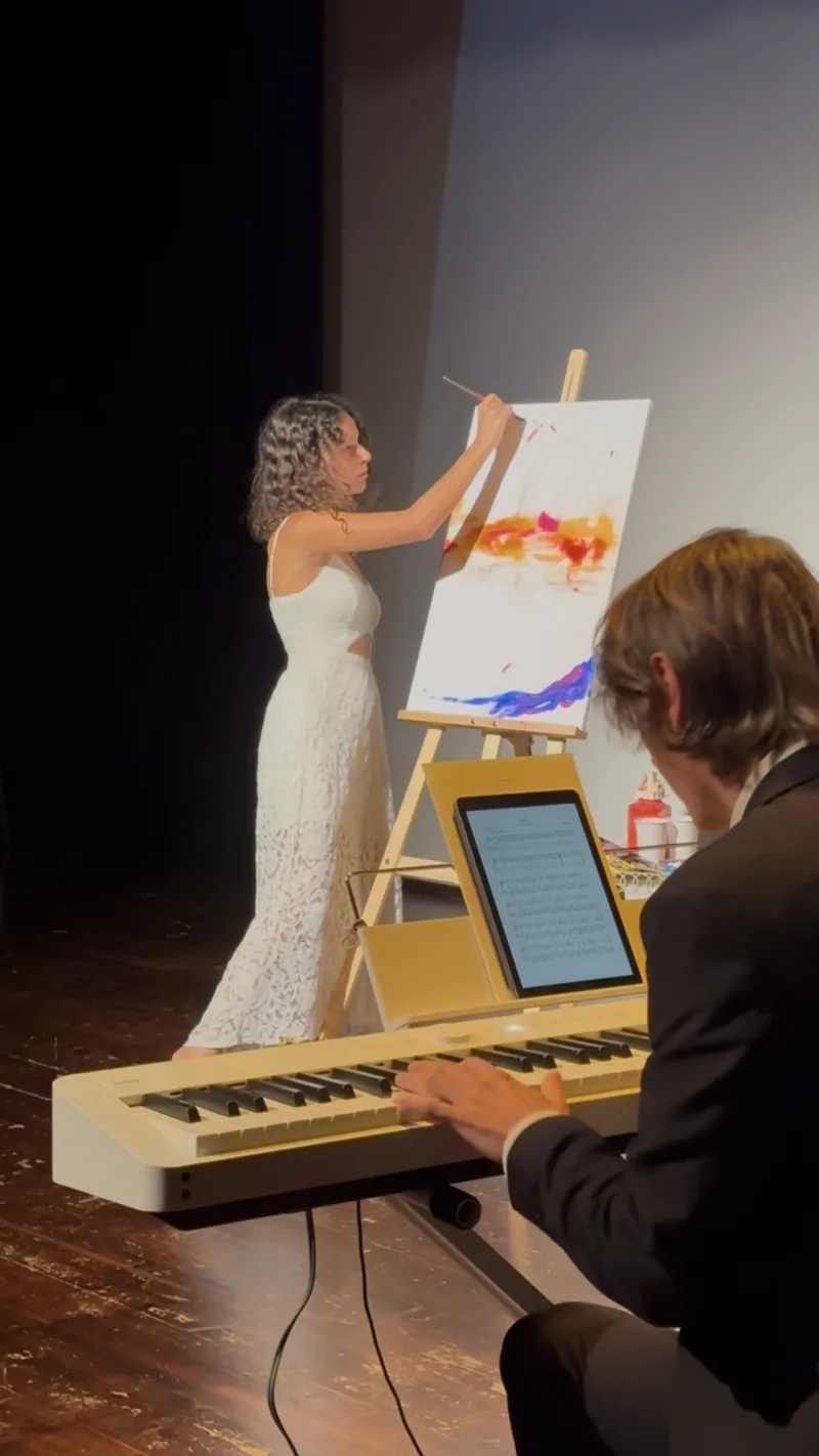 Spectacle piano et peinture : sur scène, Giulia Dal Bon pose les premières couleurs sur la toile pendant qu’Orlando joue au clavier.