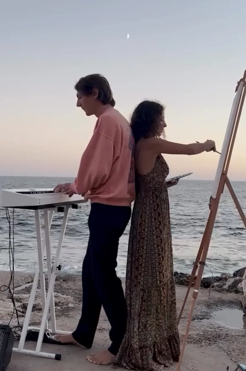 Au crépuscule, face à la mer, Orlando & Giulia jouent et peignent dos à dos, sous un fin croissant de lune.