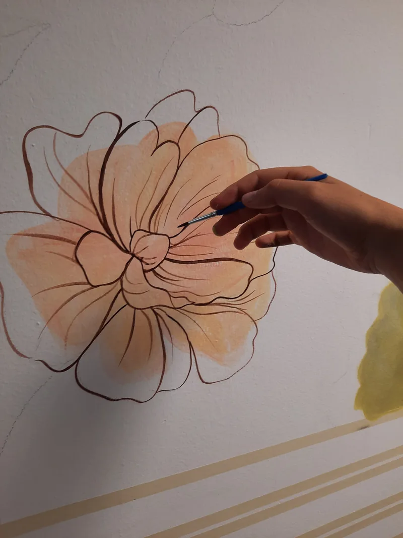 Giulia Dal Bon pose une touche de couleur pêche sur une fleur dessinée au trait.