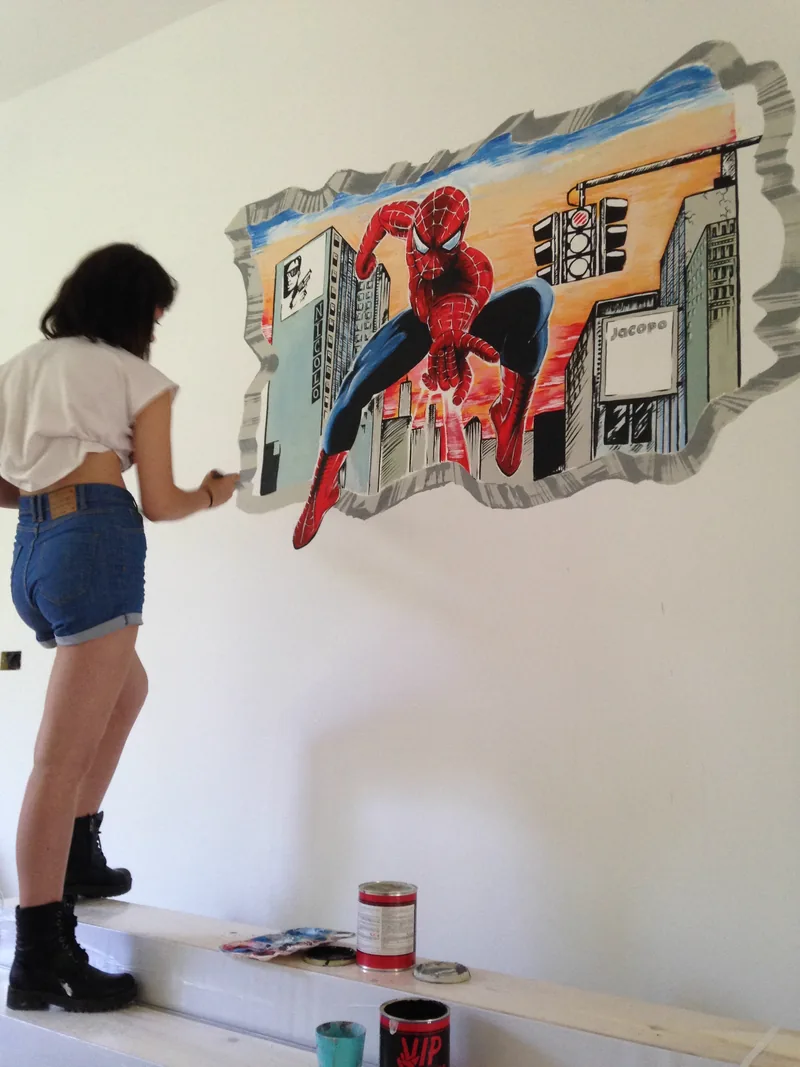 Ejemplo de mural en Segrate: en un dormitorio, Giulia Dal Bon pinta en trampantojo un superhéroe que atraviesa la pared.