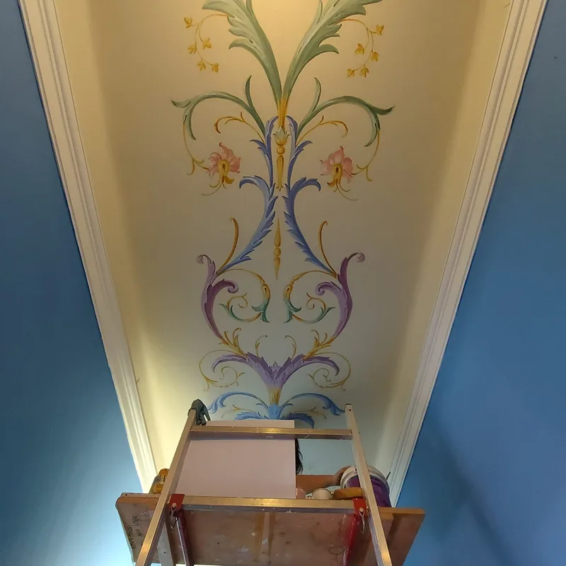 Ejemplo de mural en Capri: Giulia Dal Bon pintó roleos y flores en el techo de un pasillo.
