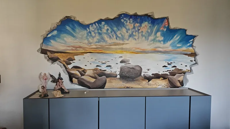 Ejemplo de mural en Alba: Giulia Dal Bon pintó en trampantojo una playa detrás de la pared.
