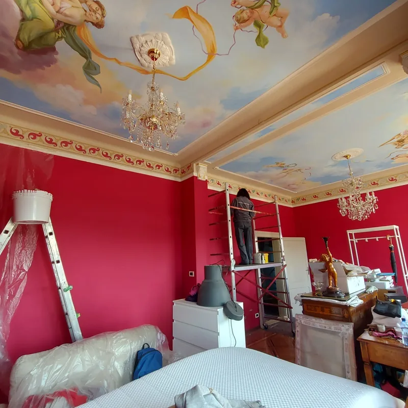 Ejemplo de mural en Arlés: en el techo de un dormitorio rojo, Giulia Dal Bon pinta angelotes entre las nubes.