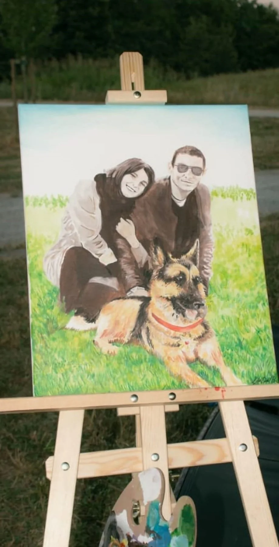 Portrait of a couple with their dog, painted on canvas on an easel