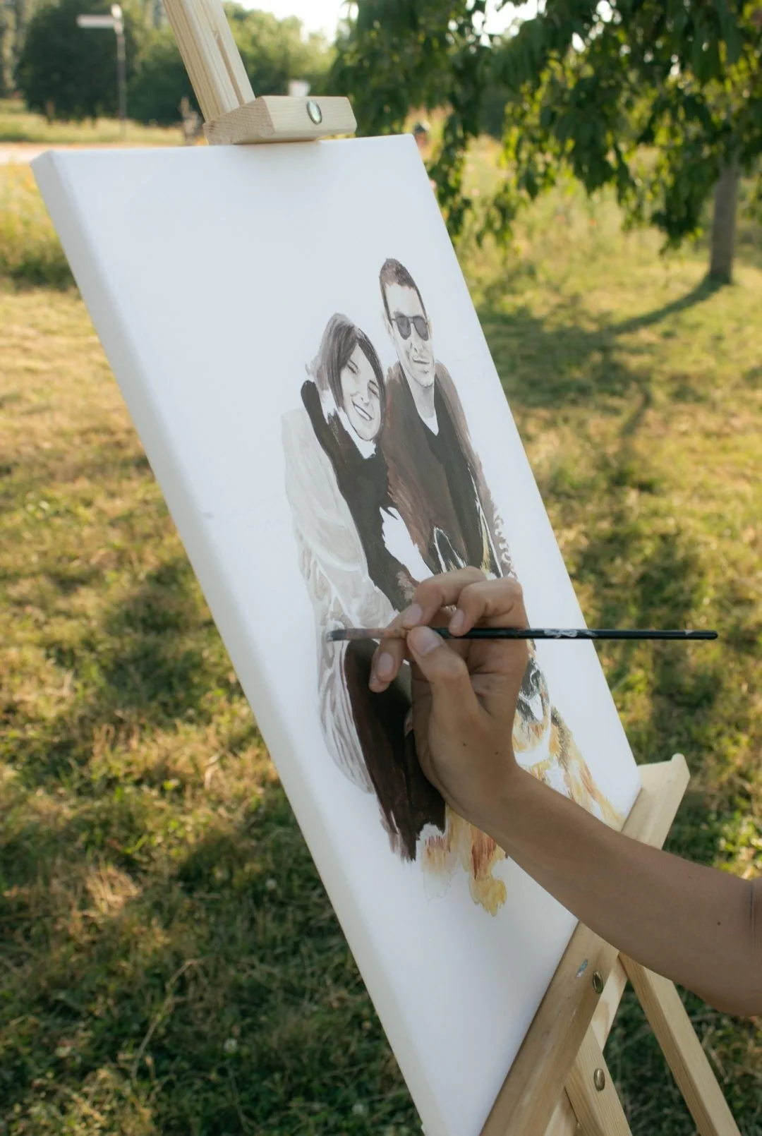 Couple portrait painted from a photo, brush working on the canvas