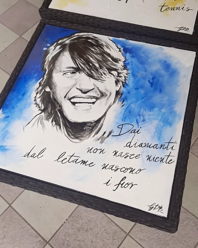 Sur fond bleu, Giulia Dal Bon a peint le sourire d’un chanteur sur le plateau d’une table, à côté des mots d’une chanson écrits à la main.