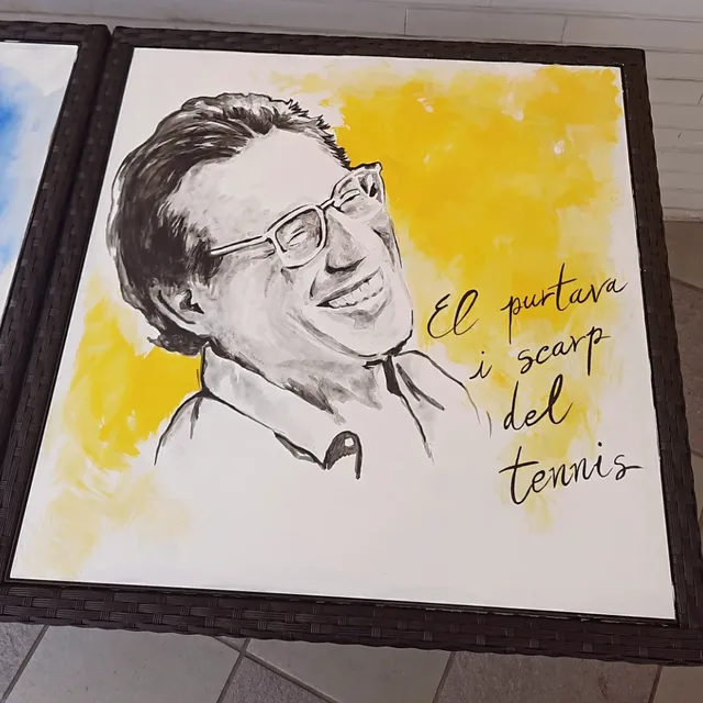Giulia Dal Bon a peint sur un plateau de table un chanteur à lunettes, en noir sur un fond jaune, avec un vers de sa chanson.